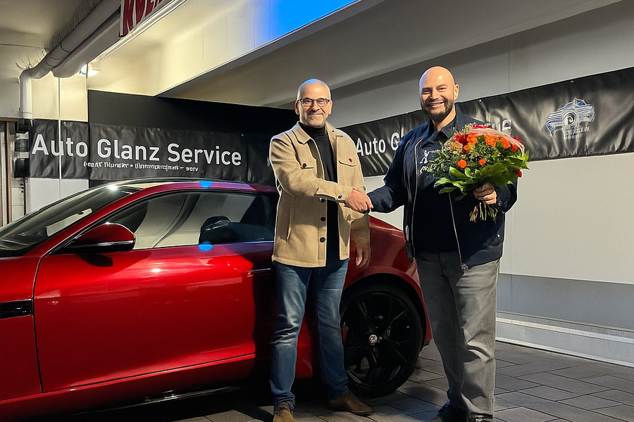 Zwei Männer geben sich die Hand vor rotem Auto bei Auto Glanz Service